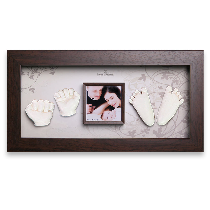 A LOVE MOM'S PRESENT Momspresent Baby Hands and Foot 3D Casting Print DIY Kit with Walnut Frame6. Autumn-flavor memory frame display featuring a baby’s handprints, footprints, and a photo. The handprints are on the left, the photo of a baby and parents is in the center, and the footprints are on the right. The dark wood frame with a light patterned background makes it a luxury baby gift.